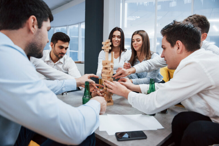 It's almost fall of. Celebrating successful deal. Young office workers sitting near the table with alcohol.